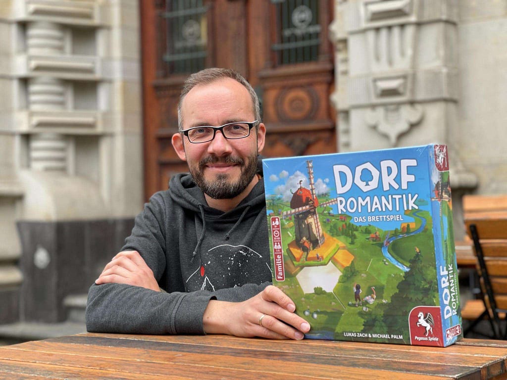 Lukas Zach mit dem Brettspiel „Dorfromantik – Das Brettspiel“, Gewinner des Spiel des Jahres 2023.